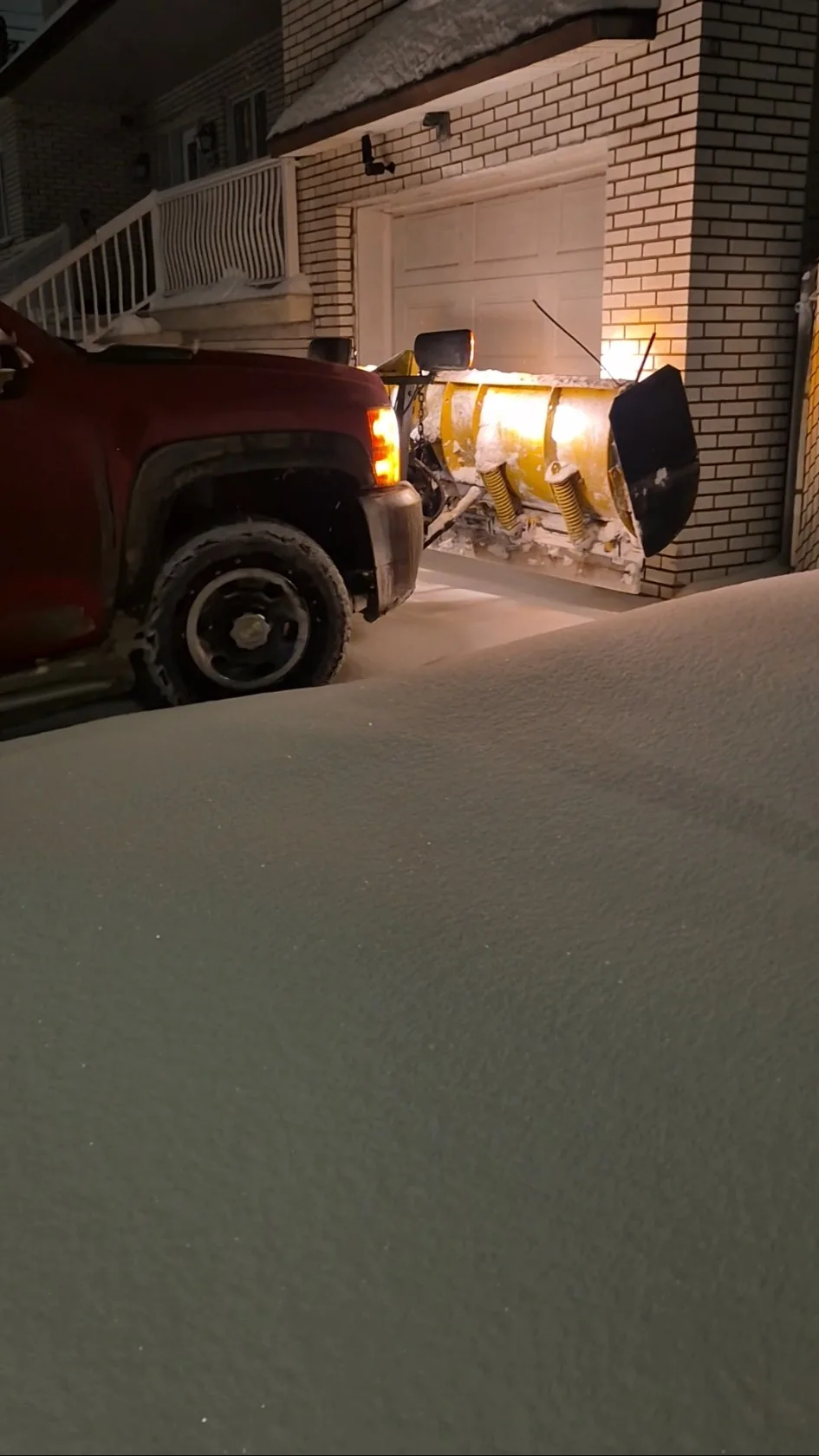 Camion de déneigement devant une entrée résidentielle